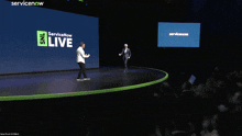 two men on a stage with a servicenow live sign
