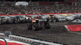 several monster trucks are racing on a dirt track with a sign that says jam on it