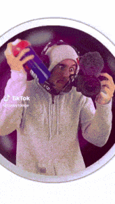 a man is taking a picture of himself with a camera while wearing a hoodie and headphones