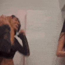 a blurry photo of two women standing next to each other in a room .