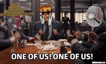 a group of people sitting around a table with the words one of us one of us on the bottom