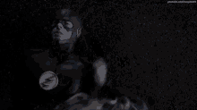 a man in a superhero costume is laying on the ground with a woman holding his hand .