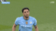 a man in an etihad shirt is kneeling down on the grass