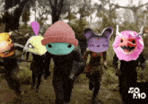 a group of people with masks on their faces are running in a forest