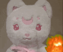 a white teddy bear with pink eyes and a crescent moon on its head