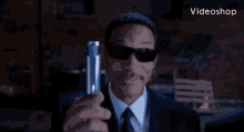 a man in a suit and tie is holding a blue light in front of his face .