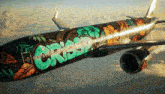 a plane with graffiti on the side that says crisp