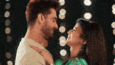 a man and a woman are looking into each other 's eyes and smiling .