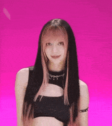 a woman with long black hair and pink streaks is holding a pair of scissors in her hand .