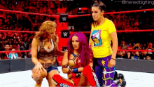 a group of women are wrestling in a ring and one of them is wearing a yellow shirt