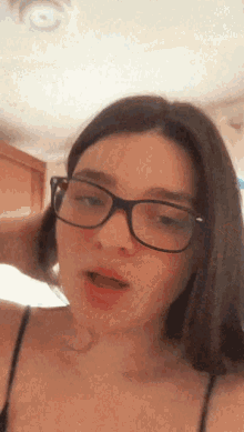 a woman wearing glasses looks at the camera with her mouth open