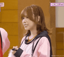 a girl in a pink jacket is smiling in front of a sign that says 1
