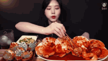 a woman is eating a plate of food with chopsticks ..
