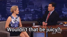 a man and a woman are sitting at a table with the words " wouldn 't that be juicy " on the screen