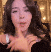 a close up of a woman 's face with a finger on her mouth