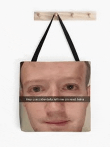 a tote bag with a picture of a man 's face on it is hanging on a wall .