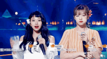 two girls are standing next to each other with microphones in their hands