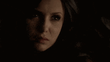 a close up of a woman 's face with her eyes closed in the dark