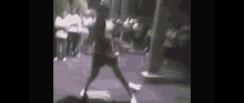 a man is dancing in front of a crowd of people .