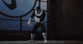 a man in a black and white superhero costume is standing in front of a window