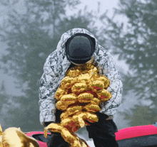 a person holding a bunch of gold balloons with the word balloons on it