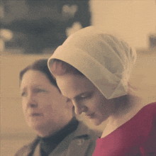 a woman wearing a white hat and a red dress looks down