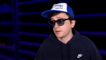 a man wearing sunglasses and a hat with a youtube subscribe button behind him