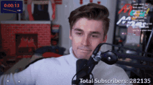 a man sitting in front of a microphone with the words total subscribers 282135
