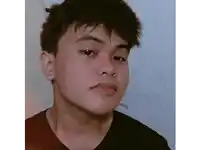 a close up of a young man 's face with a black shirt on