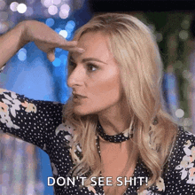 a woman in a polka dot dress is holding her hand to her forehead and saying " don 't see shit "