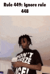 a man with dreadlocks is wearing a shirt that says ' dont freeze ' on it .