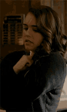 a close up of a woman wearing a black sweater with a yellow bow on her collar .