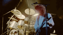 a man playing a guitar and singing into a microphone on a stage