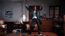 a man is jumping in the air in a room with a poster on the wall that says looks splasher