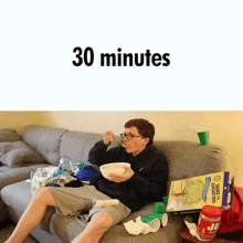 a man is sitting on a couch eating a bowl of cereal and the words 30 minutes are above him