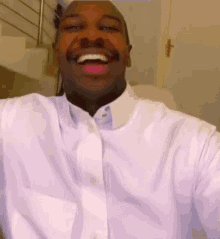 a man wearing a white shirt is smiling with a pink lip