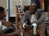 a man in a suit and tie is sitting next to a woman on a patio .