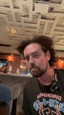 a man with a beard is wearing a shirt that says ' airending ' on it