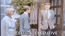 a man in a suit and tie is standing in front of a door and talking to a woman .