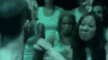 a group of people are standing in a dark room and looking at each other .