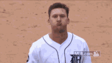 a baseball player is standing on a field with mlb.com written on the bottom of his jersey .