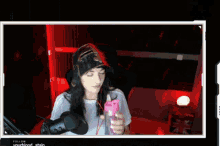 a woman wearing a hat stands in front of a microphone with the words follow yourblood stain on the bottom right