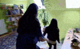 two women are standing in a room with the number 12 on the wall