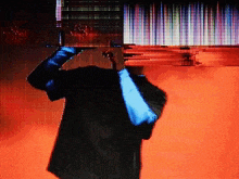 a man in a suit is standing in front of a screen with a red background