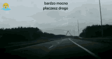 a black and white photo of a road with the words bardzo mocno placesz drogo