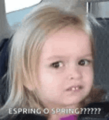 a little girl is making a funny face while sitting in a car seat .