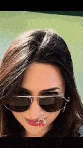 a close up of a woman wearing sunglasses with the word love on her face