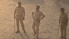 a group of police officers are standing on a dirt field