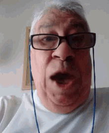 a man wearing glasses and earbuds is making a funny face