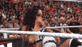 a woman in a wrestling ring covering her face with her hands